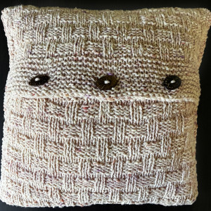 Dekoracyjna poduszka robiona na drutach z owczej wełny.