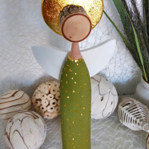 Anioł w zielonej sukience ze złotymi zdobieniami.