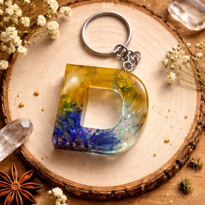 Brelok literka D z brokatem i płatkami kwiatów chaber