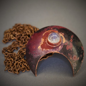 Moc, lunula miedziana z kamieniem księżycowym.