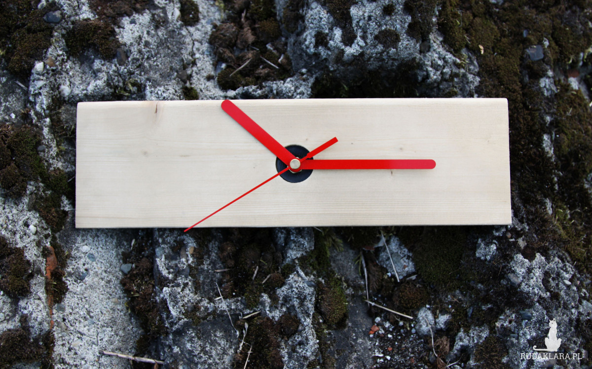 Zegar na drewnianej deseczce z czerwonymi wskazówkami