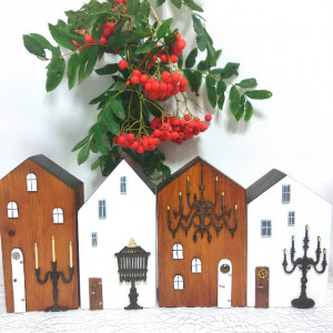 Zestaw czterech dekoracyjnych domków drewnianych.
