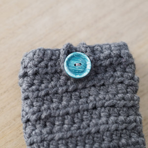 Uniwersalny pokrowiec na smartfony. Szary z turkusowym guziczkiem