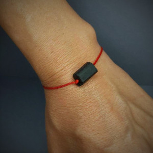 Branoletka ochronna z czarnym turmalinem na czerwonym sznurku.