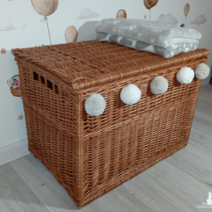 Duży wiklinowy kufer w kolorze naturalnym z pomponami