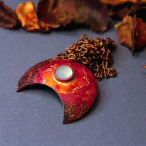 Moc, lunula miedziana z akwamarynem.