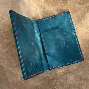 Duży turkusowy portfel ręcznie uszyty ze skóry.