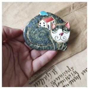 Kotek przytulający domek