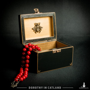 Czarna szkatułka ze złotym kwiatem oraz ze złotą pszczołą