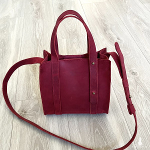Mała czerwona torebka skórzana na ramię.