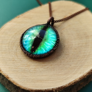 Szklane oko w miedzianej oprawie. Naszyjnik z wisiorem.