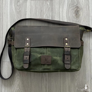 Duża zielono-brązowa torba ze skóry i bawełny woskowanej.