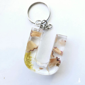 Brelok literka U przezroczysta z kredkami obierkami