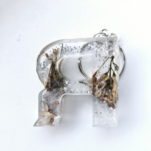 Brelok literka R przezroczysta z brokatem I kwiatem bzu