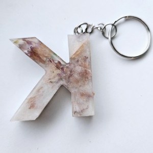 Brelok literka K przezroczysta z kredkami obierkami