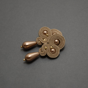 beżowe kolczyki lub klipsy sutasz