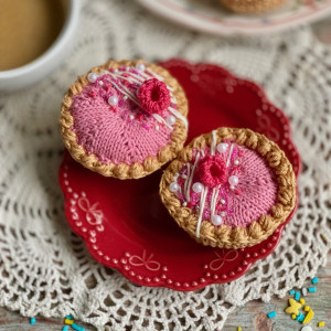 Szydełkowa babeczka malinowa z białym lukrem i koralikową posypką