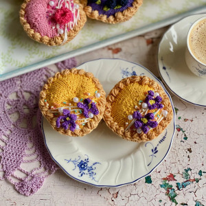 Szydełkowa babeczka z fioletowymi kwiatami i lukrem