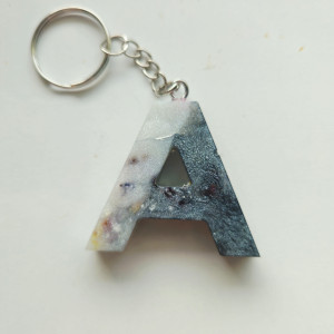 Brelok literka A z żywicy z płatkami kwiatów czernią i bielą