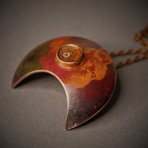 Moc, lunula miedziana z kamieniem słonecznym.