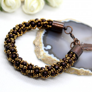 Bransoletka z brązowych perełek z piórkiem