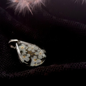 Niepowtarzalny naszyjnik z niezapominajką i na tle czarnej żywicy