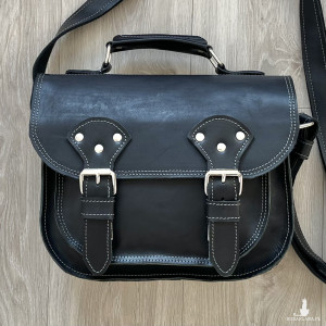 Czarna torba ze skóry na ramię obszyta szarą nitka.