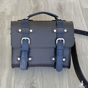 Mała brązowo-granatowa skórzana teczka na ramię.