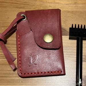 Mały skórzany czerwony portfel ręcznie uszyty na karty.