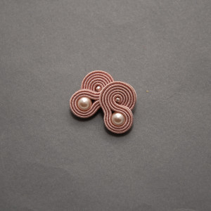 małe, różowe kolczyki lub klipsy sutasz