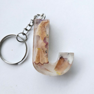 Brelok literka J przezroczysta z kredkami obierkami