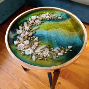 Stolik kawowy vintage z kompozycją z suszonych kwiatów na zielonym tle