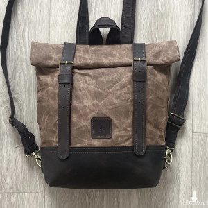 Brązowy plecak ze skóry i bawełny woskowanej zapinany na dwie klamry.