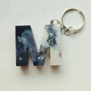 Brelok literka M z żywicy z płatkami kwiatów czernią i bielą