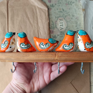 Wieszak z pomarańczowymi ptaszkami o turkusowych oczach