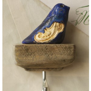 Wieszak z granatowym ptaszkiem o dekoracyjnych skrzydłach