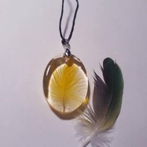 Duży owalny wisior z papuzim piórem