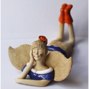 Anioł leżący z różą we włosach